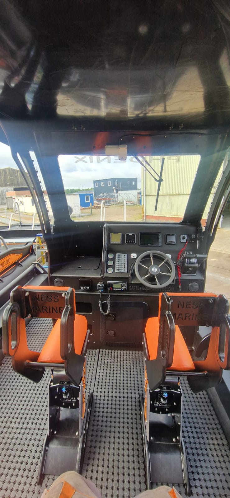 Helm console, electronics and orange bucket seats aboard the NESS Marine Phoenix workboat
