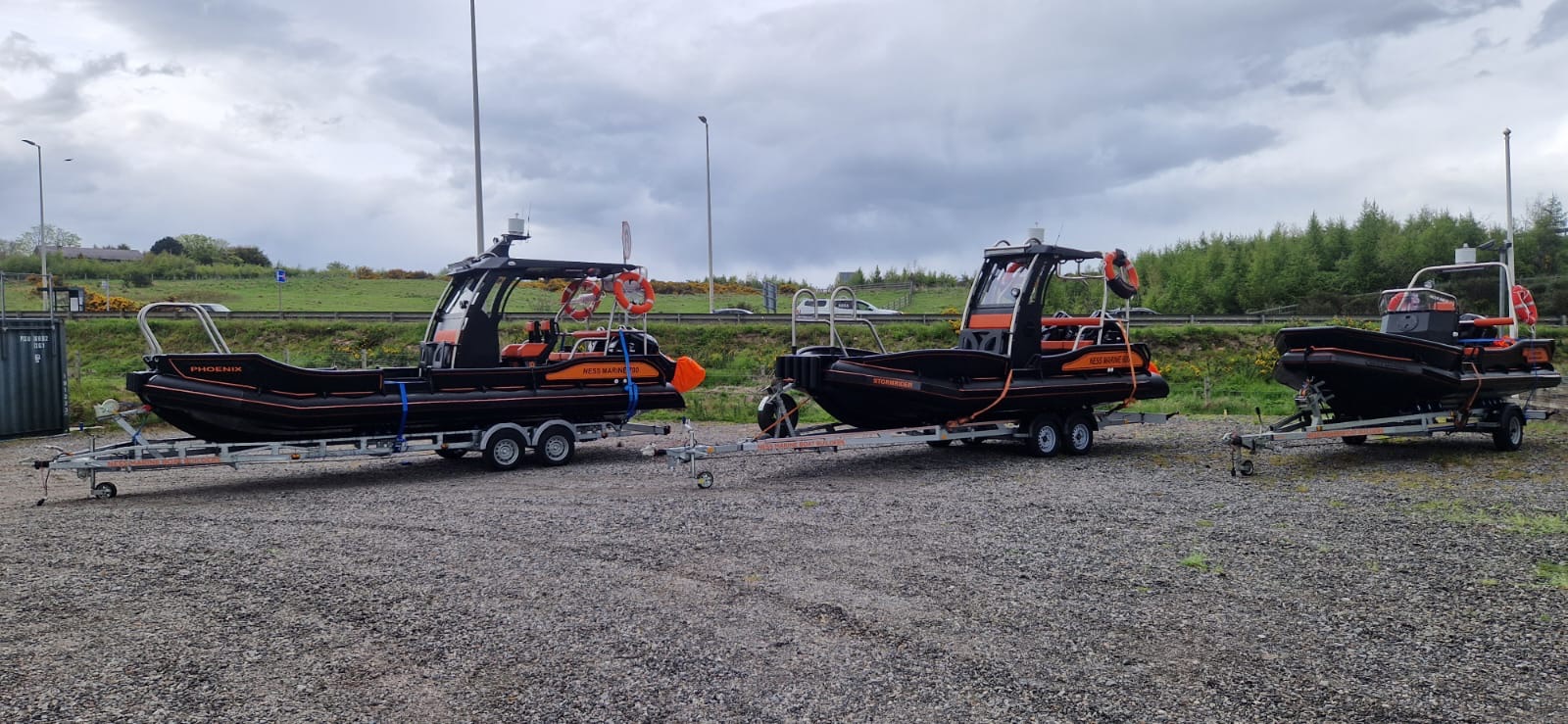 Phoenix, Stormrider and a third NESS Marine workboat lined up on trailers in a car park