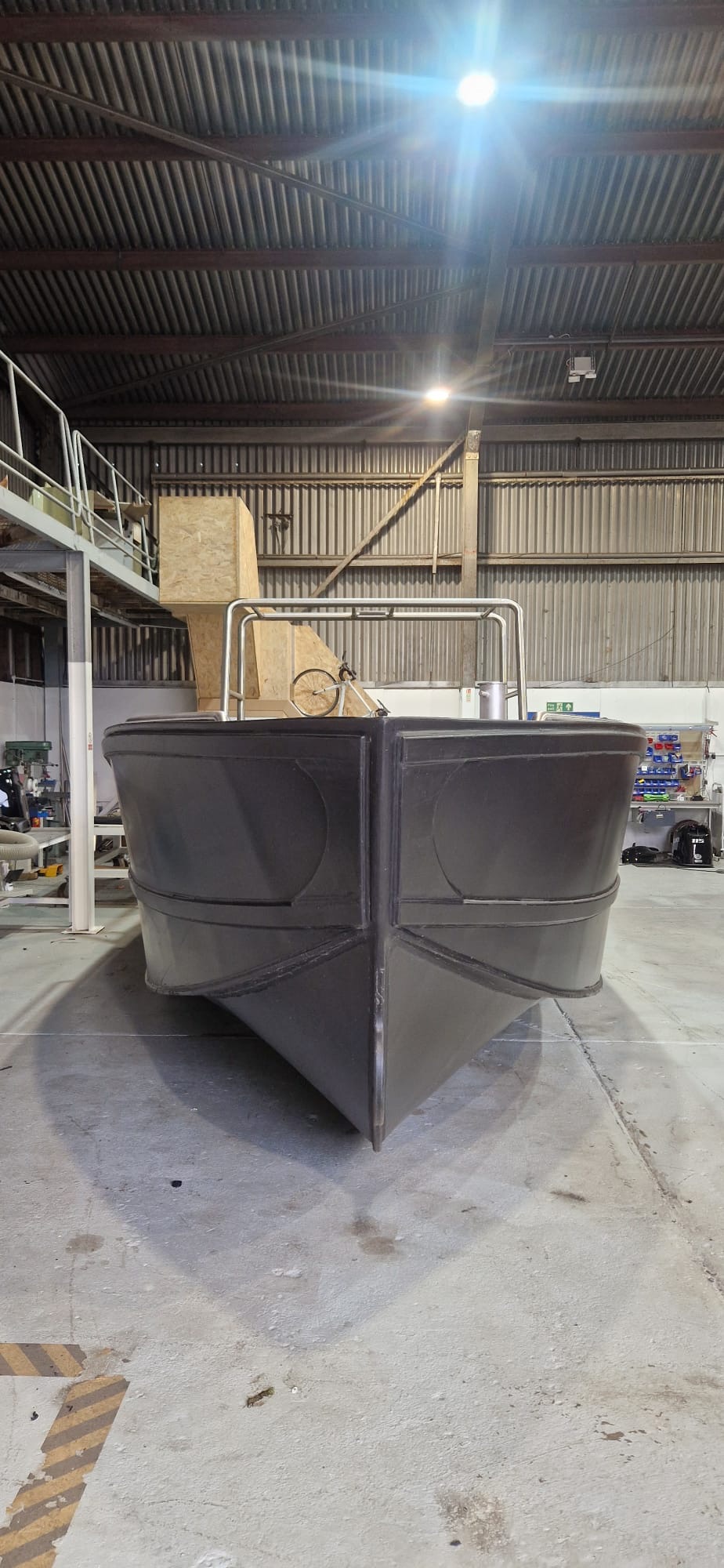 Bow-on view of an unpainted HDPE workboat hull under construction in the NESS Marine workshop